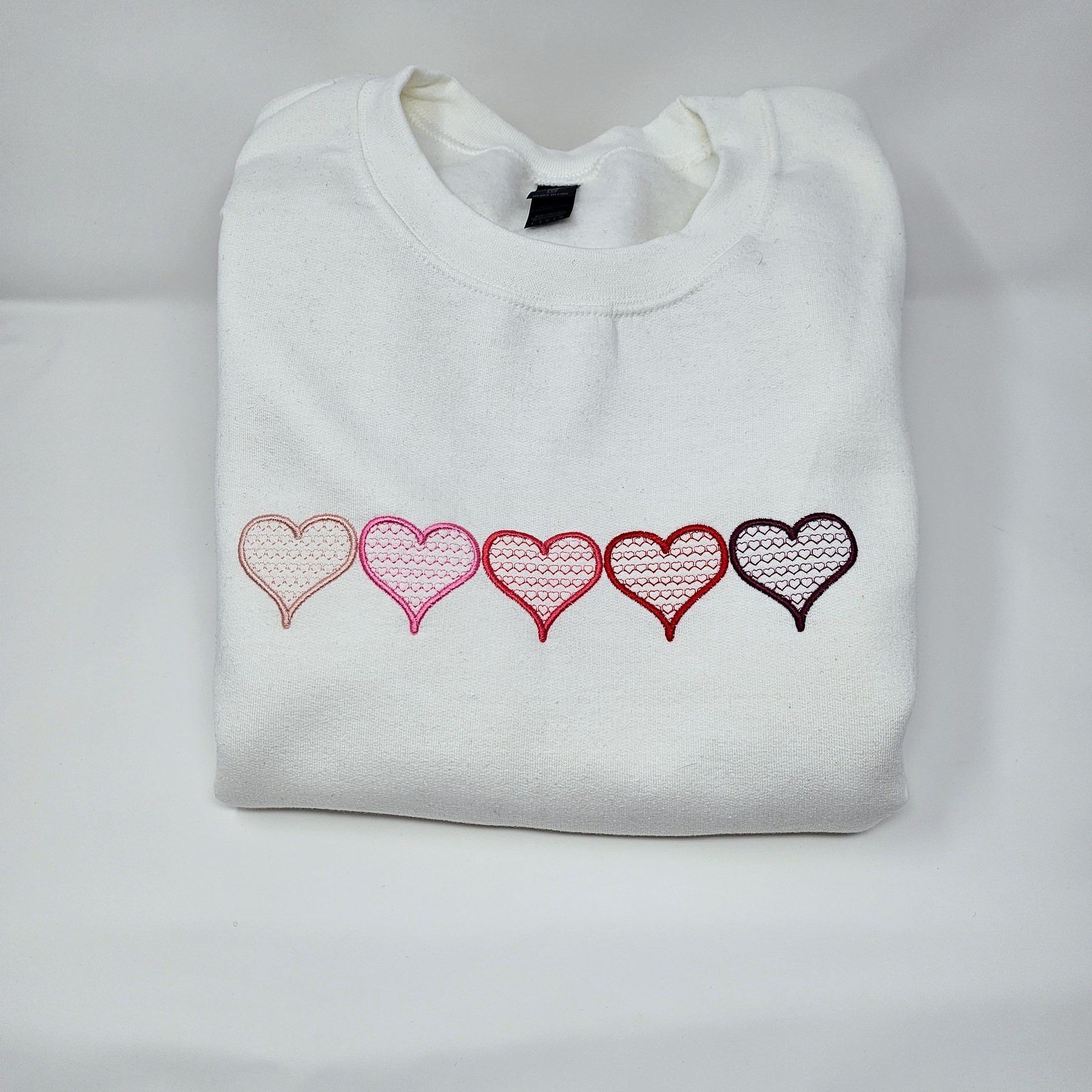White sweatshirt embroidered with hearts