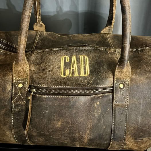 Leather travel bag with gold embroidered initials